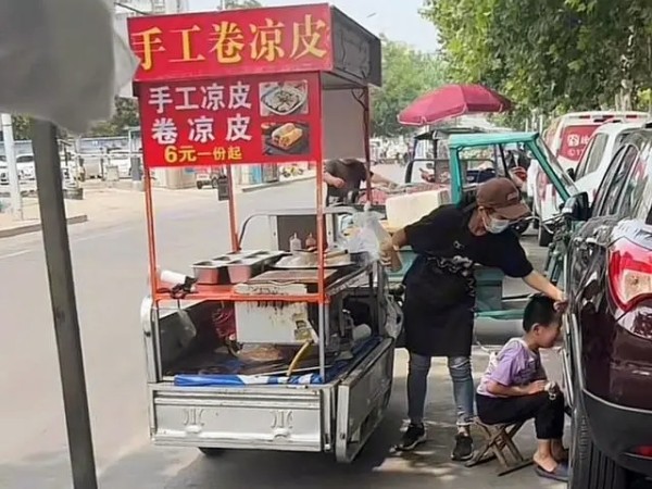 為防自閉癥兒子走失，女子擺攤用繩子將其拴在腰上（一）